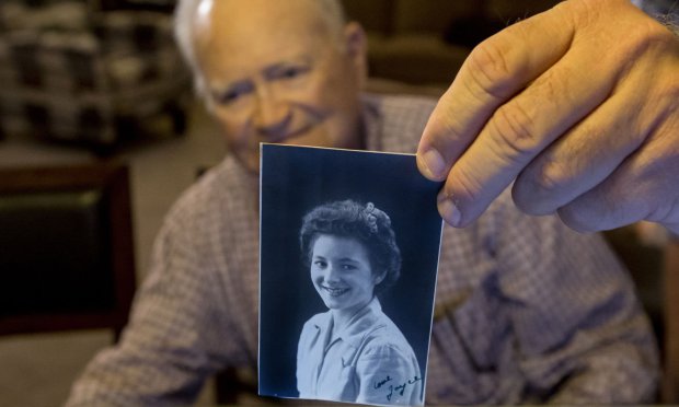 In this photo taken Nov. 6, 2015, Norwood Thomas, 93, holds up a photo of with Joyce Morris at his home in Virginia Beach, Va. During World War II, Morris lived in England and was Joyce Durrant, the girlfriend of Thomas, a D-Day paratrooper with the Army's 101st Airborne Division. Morris now lives in Australia. (Bill Tiernan/The Virginian-Pilot via AP)  MAGS OUT; MANDATORY CREDIT