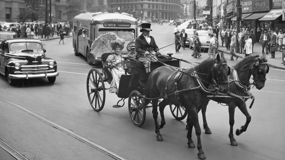 A horse-drawn carriage contrasting with the car traffic of New York City in 1947. Un attelage en contraste avec la circulation automobile de la ville de New York en 1947.