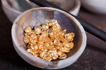 Raw gold in the pan ready to melt in the manufacturing process of jewelry made of gold. Pure, real gold on photo. Please, see other photos from this series in my portfolio: